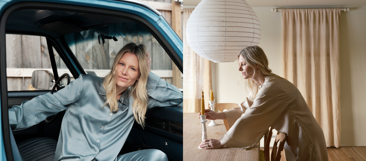 Woman in pale blue silk blouse seated in vintage blue vehicle beside woman in beige blouse arranging mustard candles on wooden table