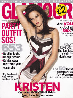 Magazine cover featuring a woman in a sleeveless geometric dress with black, white, and pink patterns posing with one arm raised.