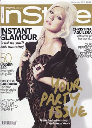 Close-up of a woman with platinum blonde hair in a dark fur-lined coat over leopard print top on a magazine cover titled InStyle