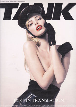 Model wearing a black leather cap and gloves with a high-waisted leather skirt, posed confidently against a plain background