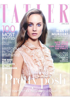 Magazine cover featuring a woman in a pale pink ruffled sleeveless blouse against a lavender background