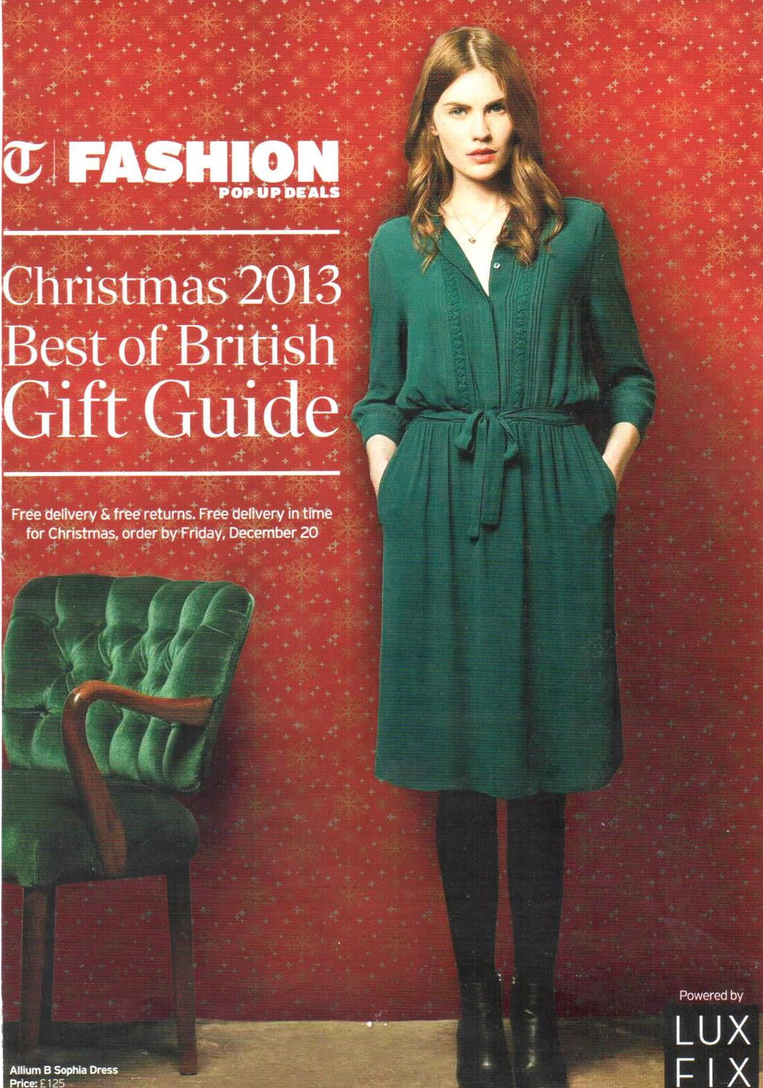 Young woman wearing a dark green long-sleeved dress with a waist tie, standing against a red wall with gold snowflake pattern