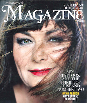 Close-up of a woman with brown hair partially covering her face, green eyes, dark eyeliner, and bright red lipstick on a dark background