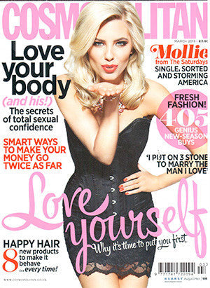 Cosmopolitan magazine cover featuring a blonde woman in a black strapless dress blowing a kiss on a white background